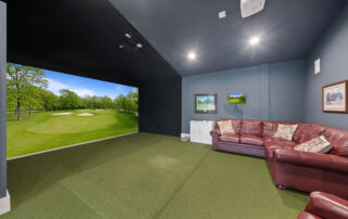entertainment spaces for custom homes Golf simulator room with red couches